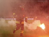 A fireman picks up fireworks during the EURO 2016 Group H Qualifier match between Italy and Croatia at Stadio Giuseppe Meazza on November 16, 2014