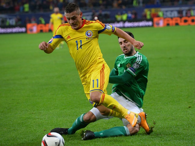 Romania's midfielder Gabriel Torje and Northern Ireland's defender Connor McLaughlin vie for the ball during the UEFA 2016 European Championship qualifying round Group F football match Romania vs Northern Ireland at the Arena Nationala stadium in Buchares