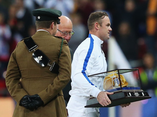 Wayne Rooney of England leaves with his 100th cap after being presented with it by Sir Bobby Charlton prior to during the EURO 2016 Qualifier Group E match vs Slovenia on November 15, 2014
