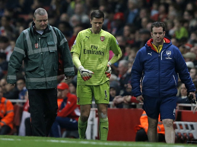 Arsenal's Polish goalkeeper Wojciech Szczesny has to leave the game after being injured in the incident leading to the opening goal in the English Premier League football match between Arsenal and Manchester United at the Emirates Stadium in London on Nov