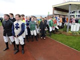 ockeys line up to observe a minutes silence after the death of former jockey and trainer Dessie Hughes at Cheltenham racecourse on November 16, 2014