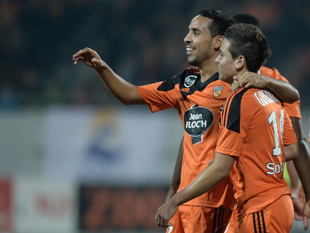 Lorient's French Portuguese defender Raphael Guerreiro celebrates with Lorient's French Algerian midfielder Walid Mesloub during the French L1 football match between Lorient and Lens at the Moustoir stadium in Lorient, western France, on November 22, 2014