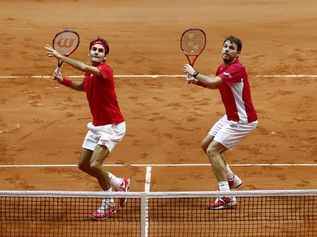 Roger Federer of Switzerland and Stanislas Wawrinka of Switzerland in action against Richard Gasquet of France and Julien Benneteau of France in the doubles during day two of the Davis Cup Tennis Final between France and Switzerland at the Stade Pierre Ma