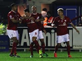 Wes Fletcher (#9) of York City is congratulated by team mates after opening the scoring during the FA Cup First Round Replay between AFC Wimbledon and York City at The Cherry Red Records Stadium on November 18, 2014