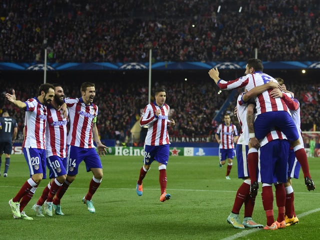 Atletico Madrid's players celebrate after scoring their fourth goal during the UEFA Champions League Group A football match Club Atletico de Madrid vs Olympiakos FC at the Vicente Calderon stadium in Madrid November 26, 2014