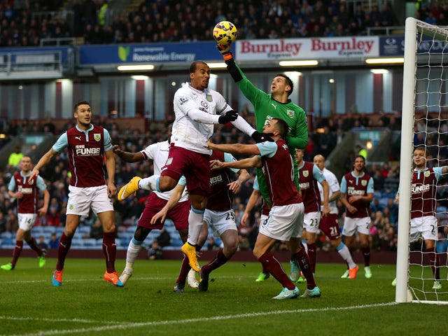 Thomas Heaton of Burnley punches clear under pressure from Gabriel Agbonlahor of Aston Villa during the Barclays Premier League match between Burnley and Aston Villa at Turf Moor on November 29, 2014