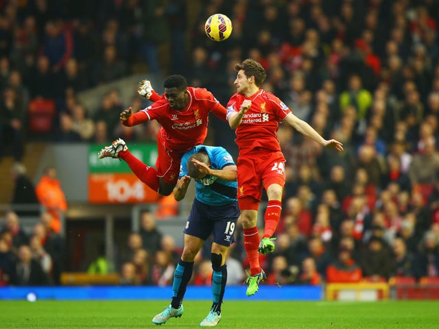Kolo Toure and Joe Allen of Liverpool outjump Jonathan Walters of Stoke City during the Barclays Premier League match between Liverpool and Stoke City at Anfield on November 29, 2014 