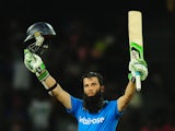 England cricketer Moeen Ali raises his bat and helmet in celebration after scoring a century (100 runs) during the first One Day International (ODI) match between Sri Lanka and England at the R. Premadasa Cricket Stadium in Colombo on November 26, 2014