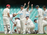 Phil Hughes lies on the ground surrounded by teammates after taking a knock to the head on November 25, 2014