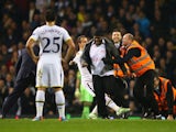  Roberto Soldado of Spurs attempts to tackle a pitch invader as stewards apprehend him during the UEFA Europa League group C match between Tottenham Hotspur FC and FK Partizan at White Hart Lane on November 27, 2014