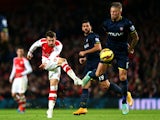 Aaron Ramsey of Arsenal shoots past Toby Alderweireld of Southampton during the Barclays Premier League match between Arsenal and Southampton at Emirates Stadium on December 3, 2014 