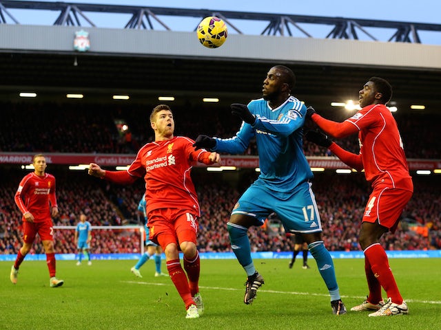 Jozy Altidore of Sunderland battles for the ball with Kolo Toure and Alberto Moreno of Liverpool during the Barclays Premier League match on December 6, 2014