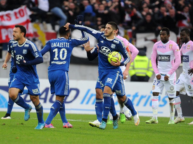 Lyon's French forward Yassine Benzia celebrates with teammates after scoring an equalizer during the French L1 football match Evian (ETGFC) against Lyon (OL) on December 7, 2014