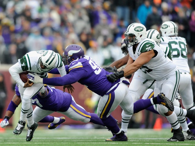 Geno Smith #7 of the New York Jets avoids a sack by Everson Griffen #97 and Tom Johnson #92 of the Minnesota Vikings during the second quarter of the game on December 7, 2014