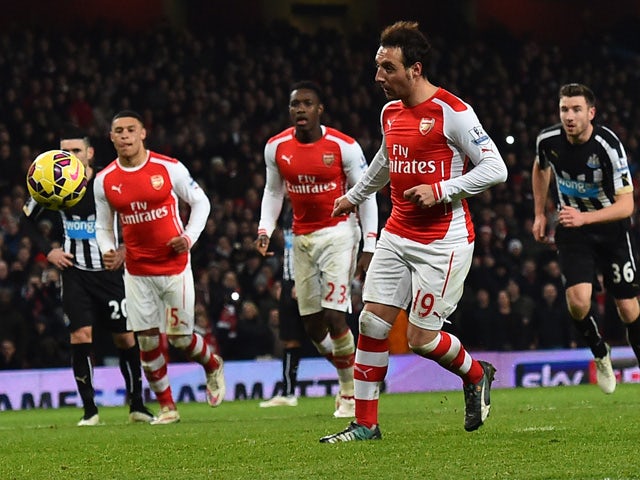 Arsenal's Spanish midfielder Santi Cazorla chips the ball as he scores their fourth goal from the penalty spot during the English Premier League football match between Arsenal and Newcastle United at the Emirates Stadium in London on December 13, 2014