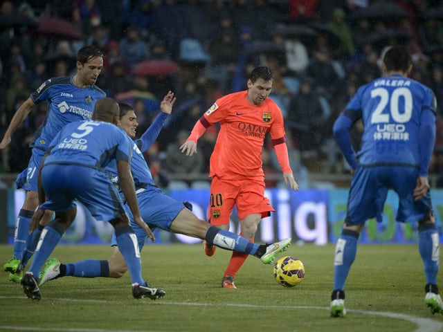 Getafe's Uruguayan defender Emiliano Velazquez vies with Barcelona's Argentinian forward Lionel Messi during the Spanish league football match Getafe CF vs FC Barcelona at the Col. Alfonso Perez stadium in Getafe on December 13, 2014