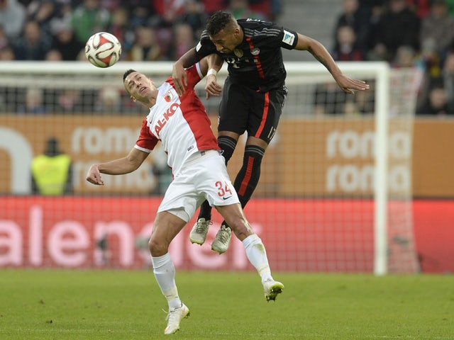 Bayern Munich's defender Jerome Boateng and Augsburg's Serbian midfielder Nikola Djurdijic vie for the ball during the German First division Bundesliga football match FC Augsburg vs FC Bayern Muenchen in Augsburg, southern Germany, on December 13, 2014