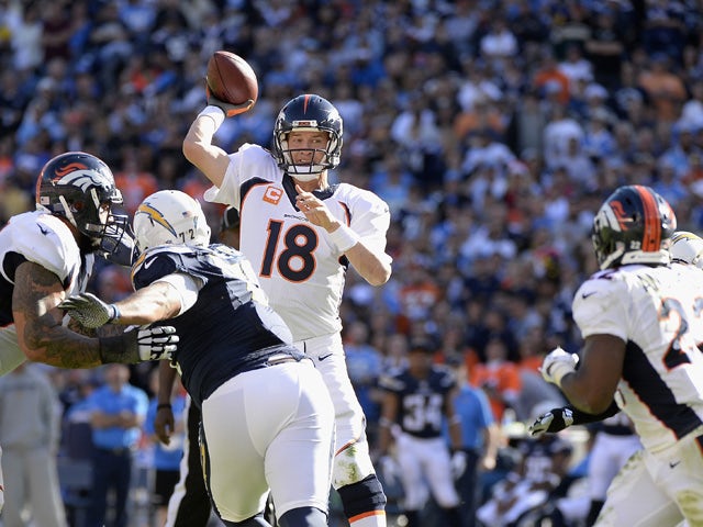 Quarterback Peyton Manning #18 of the Denver Broncos looks to pass agianst the San Diego Chargers defense at Qualcomm Stadium on December 14, 2014