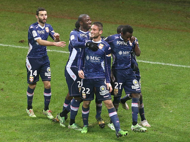 Evian's teammates celebrate after Evian's French midfielder Cedric Cambon celebrates after scoring a goal during the French L1 Football match Reims vs Evian, on December 13, 2014