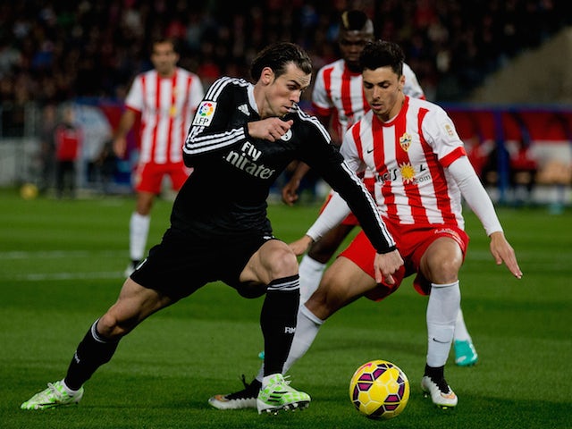 Gareth Bale (L) of Real Madrid CF competes for the ball with Joaquin Navarro JImenez (R) of Almeria UD during the La Liga match on December 12, 2014