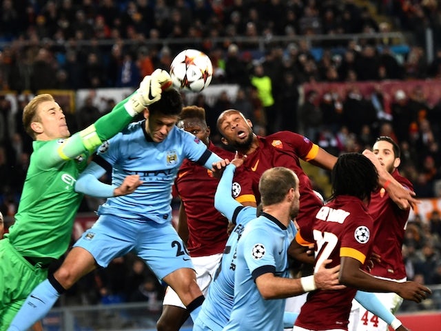 Manchester City's English goalkeeper Joe Hart (L) jumps to deflect the ball during the UEFA Champions League football match AS Roma vs Manchester City on December 10, 2014