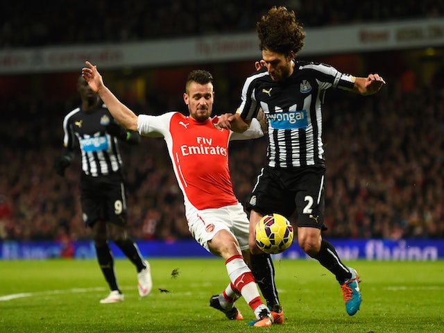 Mathieu Debuchy of Arsenal tackles Fabricio Coloccini of Newcastle United during the Barclays Premier League match on December 13, 2014