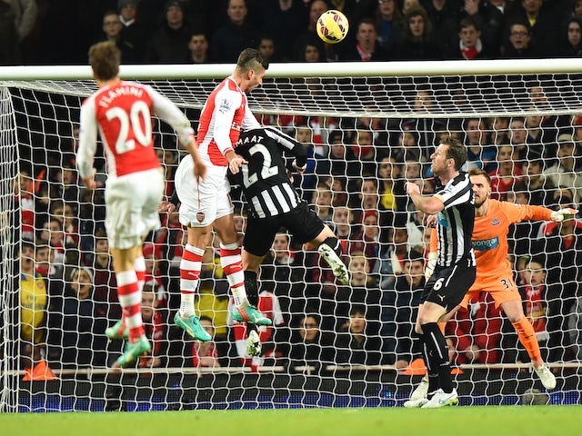 Arsenal's French striker Olivier Giroud (C) rises highest to head the ball to score the opening goal during the English Premier League football match against Newcastle United on December 13, 2014