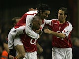 Arsenal's Robert Pires (top) and Mathieu Flamini (R) congratulate Thierry Henry after he scored the opening goal against Chelsea during the Premiership match on December 12, 2004