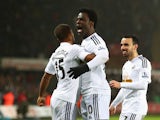 Wilfried Bony of Swansea City celebrates his goal with Wayne Routledge (L) and Leon Britton during the Barclays Premier League match between Swansea City and Tottenham Hotspur at Liberty Stadium on December 14, 2014