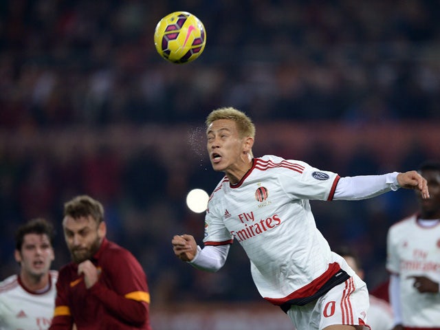 AC Milan's midfielder from Japan Keisuke Honda heads the ball against Roma during the serie A football match in Rome's Olympic Stadium on December 20, 2014