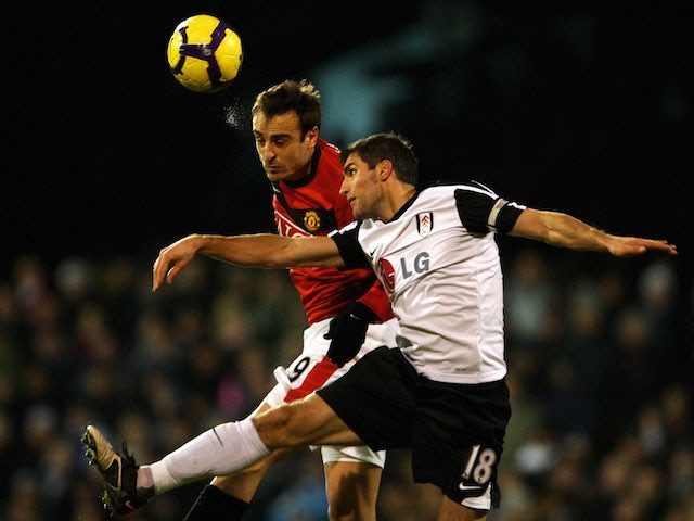 Dimitar Berbatov of Manchester United wins a header under pressure from Aaron Hughes of Fulham during the Barclays Premier League match on December 19, 2009