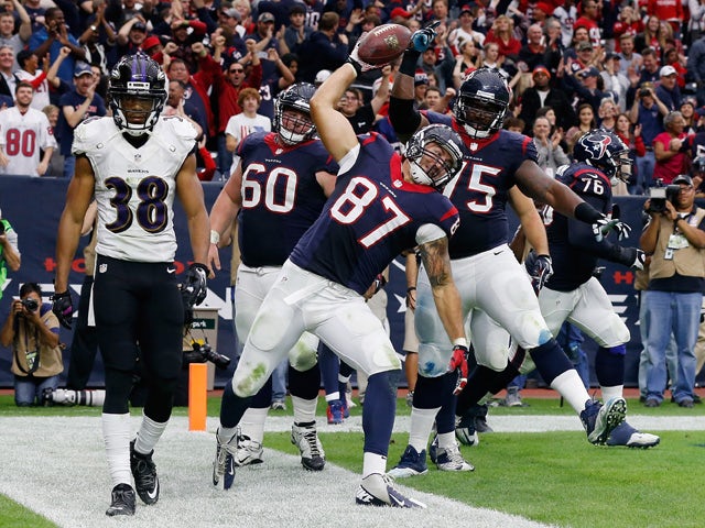 C.J. Fiedorowicz #87 of the Houston Texans spikes the ball in front of Rashaan Melvin #38 of the Baltimore Ravens after scoring a second-half touchdown during their game at NRG Stadium on December 21, 2014
