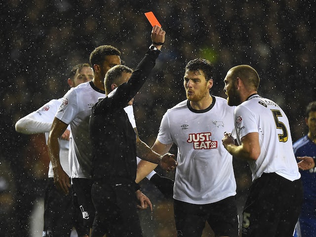 Jake Buxton (R) of Derby is shown the red card by referee Jonathan Moss during the Capital One Cup Quarter-Final match against Chelsea on December 16, 2014