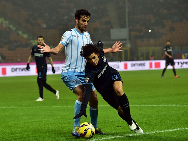 Lazio's midfielder Marco Parolo fights for the ball with Inter Milan's defender from Brazil Dodo during their Serie A football match Inter Milan vs Lazio at San Siro Stadium in Milan on December 21, 2014