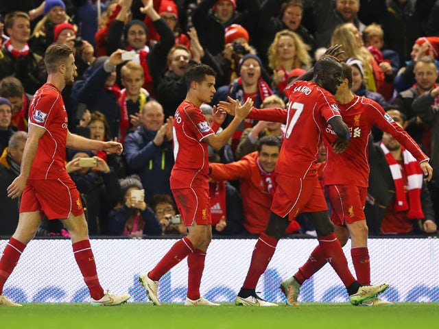 Philippe Coutinho of Liverpool celebrates his goal with team mates during the Barclays Premier League match between Liverpool and Arsenal at Anfield on December 21, 2014