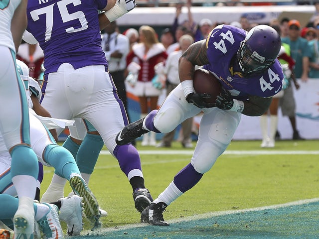 Running back Matt Asiata #44 of the Minnesota Vikings scores a first quarter touchdown against the Miami Dolphins during a game at Sun Life Stadium on December 21, 2014