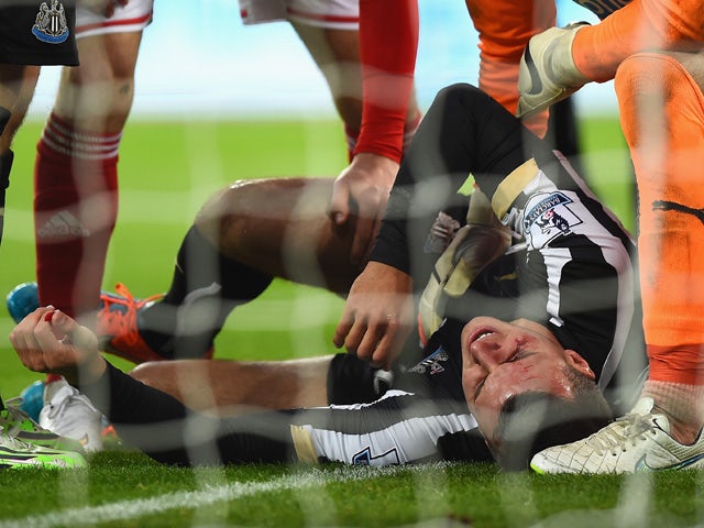 Steven Taylor of Newcastle United lies on the ground injured after colliding with the post during the Barclays Premier League match between Newcastle United and Sunderland at St James' Park on December 21, 2014 in