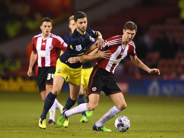 Shane Long of Southampton challenges Chris Basham of Sheffield United during the Capital One Cup Quarter-Final match on December 16, 2014