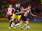 Shane Long of Southampton challenges Chris Basham of Sheffield United during the Capital One Cup Quarter-Final match on December 16, 2014