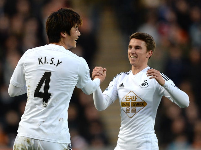 Ki Sung-Yueng of Swansea City celebrates scoring the opening goal with team-mate Tom Carroll during the Barclays Premier League match between Hull City and Swansea City at KC Stadium on December 20, 2014