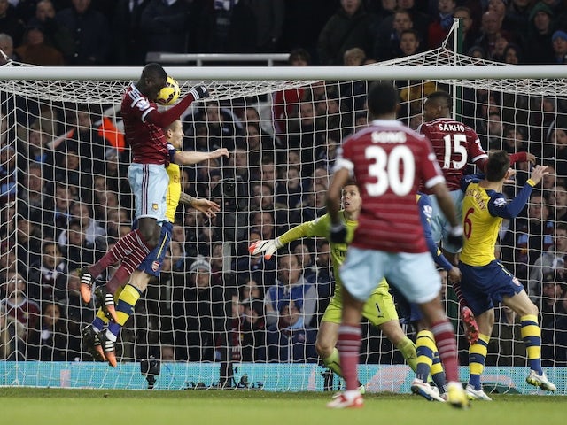 West Ham United's Senegalese midfielder Cheikhou Kouyate (L) scores their first goal during the English Premier League football match against Arsenal on December 28, 2014