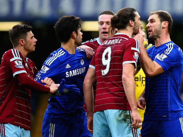 Andy Carroll of West Ham clashes with Branislav Ivanovic of Chelsea during the Barclays Premier League match between Chelsea and West Ham United at Stamford Bridge on December 26, 2014