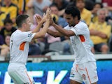 Jean Carlos Solorzano of the Roar celebrates a goal with team mate Matthew McKay during the round 13 A-League match against the Central Coast Mariners on December 27, 2014