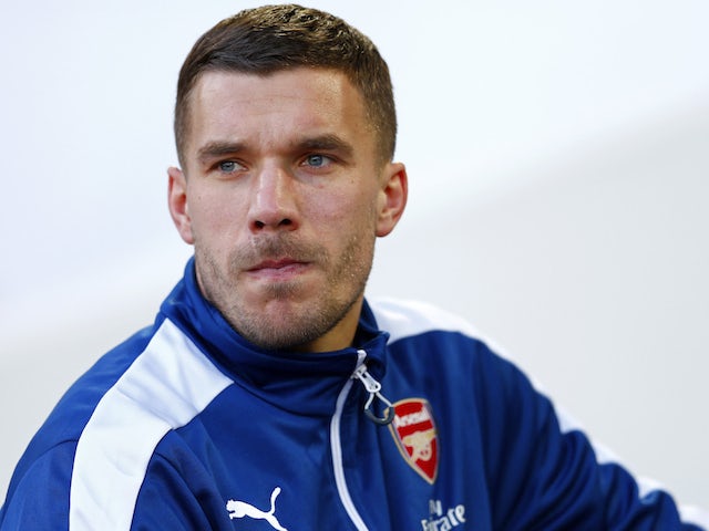 Lukas Podolski of Arsenal takes his seat on the bench before the Barclays Premier League match between West Ham United and Arsenal at Boleyn Ground on December 28, 2014