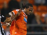 Nathan Delfouneso of Blackpool holds off a challenge from Ikechi Anya of Watford during the Sky Bet Championship match between Blackpool and Watford at Bloomfield Road on September 16, 2014