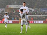 Gylfi Sigurdsson of Swansea City celebrates with Jefferson Montero as he scores their first goal during the Barclays Premier League match between Swansea City and Aston Villa at Liberty Stadium on December 26, 2014