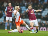 Joe Cole of Aston Villa is tackled by David Perkins of Blackpool during the FA Cup Third Round match between Aston Villa and Blackpool at Villa Park on January 4, 2015