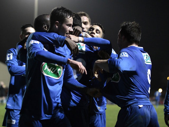 Avranches' forward Vincent Crehin celebrates with teammates after scoring a goal during a French Cup round of 64 football match between Avranches and Lorient on January 3, 2015