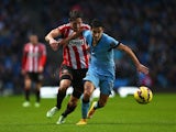 Jesus Navas of Manchester City is challenged by Billy Jones of Sunderland during the Barclays Premier League match between Manchester City and Sunderland at Etihad Stadium on January 1, 2015