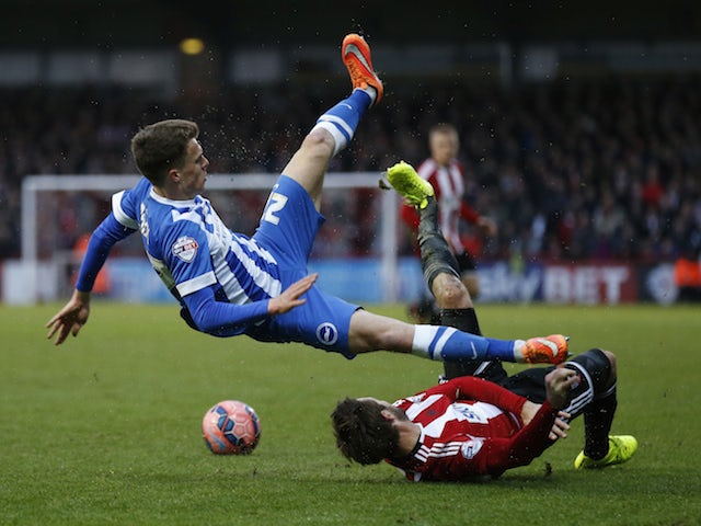 Solly March of Brighton & Hove Albion is tackled by Tommy Smith of Brentford during the FA Cup Third Round match on January 3, 2015